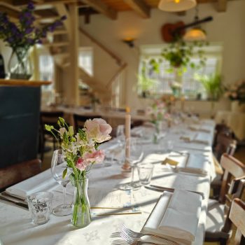 Long table setup for private dining at Markerhuisje Amsterdam. Guests enjoying festive group dinner.